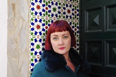 Kirsty Logan standing next to patterned wall tiles